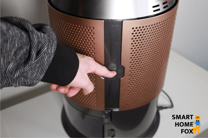 Der Schieberegler an der Seite des Luftgitters vom Dyson Purifier Humidify+Cool Formaldehyde PH04 wird nach unten gedrückt.